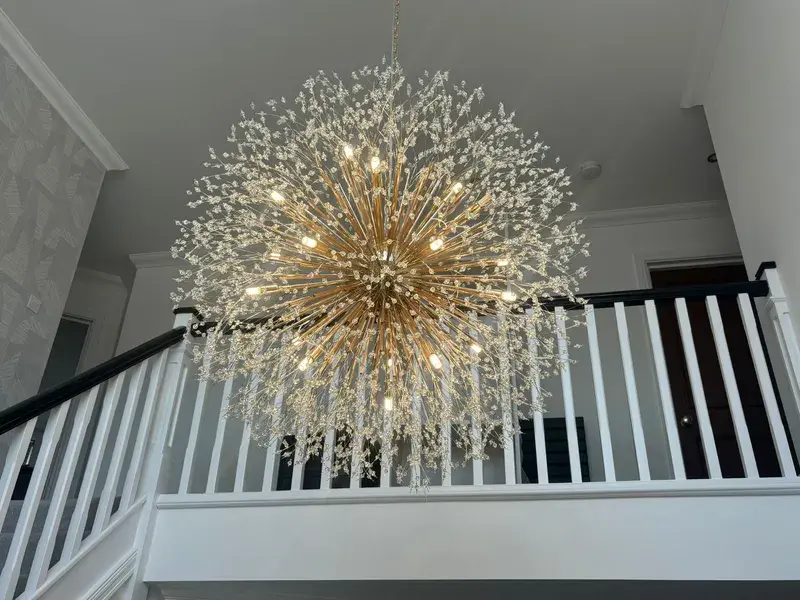 Starburst chandelier installed in double-height stairwell in Poole home