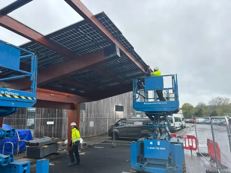 Commercial solar carport installation with cherry picker at leisure centre